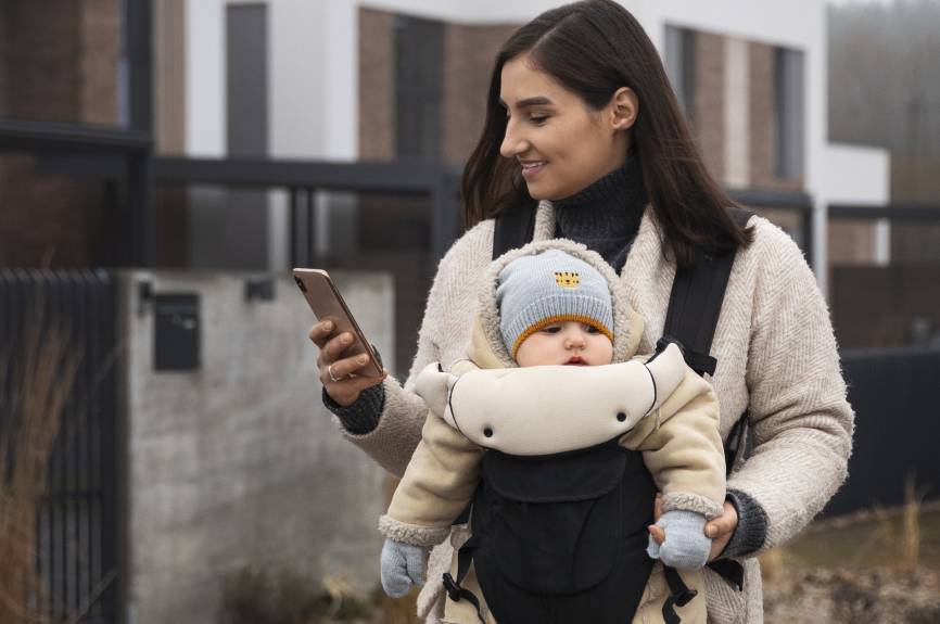 Baby in draagzak bij moeder.