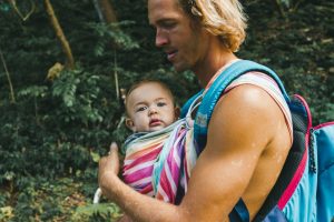 woman in blue tank top carrying baby in pink and white stripe shirt